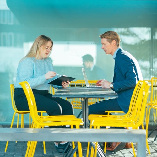 Mann og dame sitter i et jobbmøte på en kafe